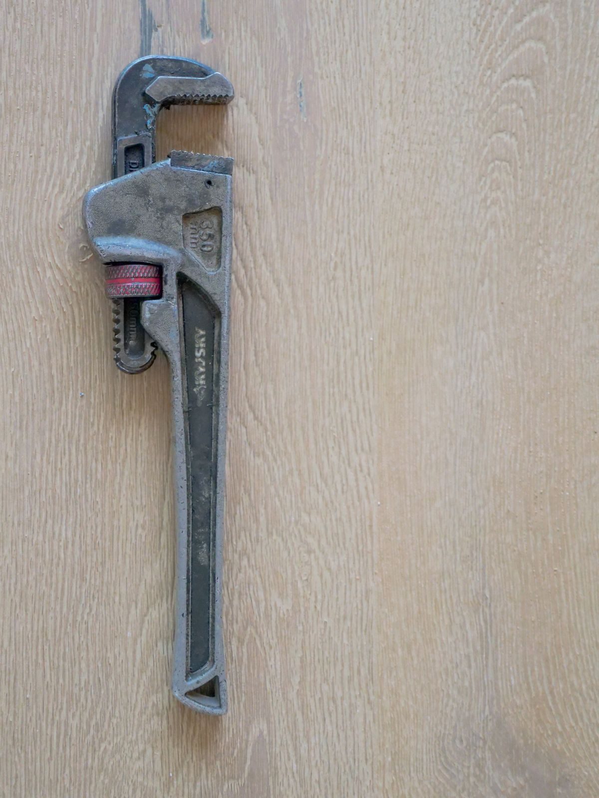 Pipe wrench on a wooden workbench